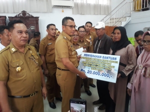 Pj Wali Kota Baubau, Rasman Manafi saat menyerahkan bantuan kepada penerima manfaat