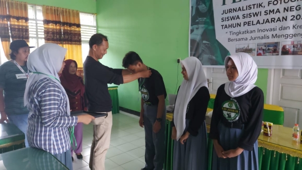 Kepala SMAN 3 Baubau La Ode Mustafa menyematkan tanda peserta Pelatihan Jurnalis SMAN 3 Baubau