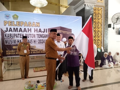 Pj Bupati Buteng H Kostantinus Bukide menyerahkan bendera merah putih kepada ketua rombongan saat melepas JCH Buteng di Masjid Nurul Huda, Lakudo
