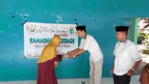 Kepala SMAN 3 Baubau La Ode Mustafa, S.Pd saat menyerahkan Santunan pada Program Ramadhan Berbagi Bersama Keluarga Besar SMAN 3 Baubau Rabu (19/4/2023)
